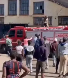 Reaction As Residents Use Buckets to Pour Water Into A a Fire Truck in Front of a Burning Building. (Video)